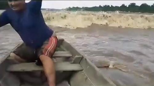 Homem usa canoa para "surfar" nas ondas da pororoca no Amapá